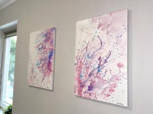 two pieces of art hanging on a wall at MMRent Pink Fusion Room in Gdańsk