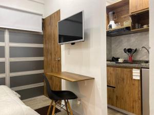 a room with a bed and a desk with a television at Acogedor Loft en Bogotá in Bogotá