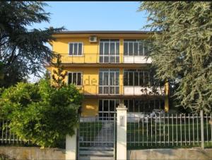 une maison jaune avec une clôture devant elle dans l'établissement Villa Sartori, à Legnago
