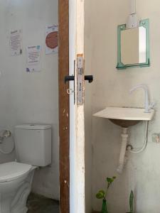 a bathroom with a toilet and a sink at Hostel Flor da Vida in Canoa Quebrada