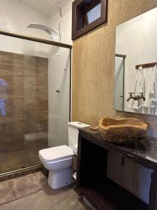 La salle de bains est pourvue de toilettes et d'une douche en verre. dans l'établissement Casa da Ilha, à Praia de Araçatiba