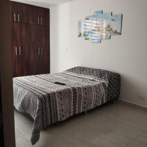 una camera da letto con un letto coperto di Apartamento cómodo y divertido a Cartago