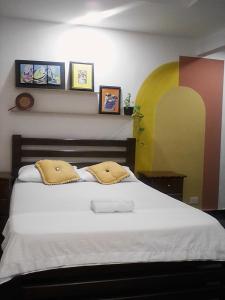 una camera da letto con un grande letto bianco con due cuscini di Casa Turistica Zamboss a Montería