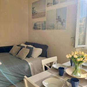 a living room with a bed and a table with flowers at Domus Lido in Lido di Ostia
