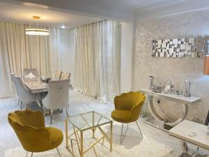 a living room with a table and yellow chairs at The Vittins in Accra