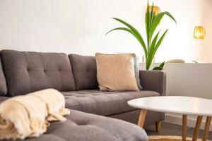 a living room with a gray couch and a table at The Sunny Flair, Relaxing Experience in Morro del Jable