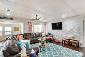 Una sala de estar con un sofá y un televisor. en Steps to Surfside Beach Home with Deck and Fire Pit!, en Surfside Beach