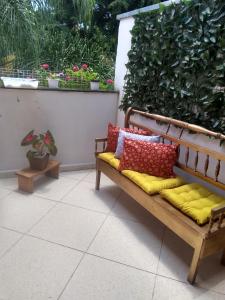 un banco con almohadas coloridas sentado en un patio en Casa & Hospedagem Carol, en Cachoeira Paulista