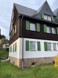 een huis met groene luiken aan de zijkant bij Natur pur im Erzgebirge in Breitenbrunn