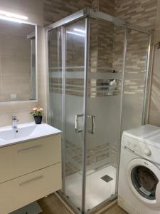 un bagno con doccia e lavatrice di Green Beach Las Canteras a Las Palmas de Gran Canaria Altre 12 foto