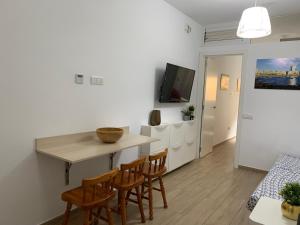 una cucina e una sala da pranzo con tavolo e sedie di Green Beach Las Canteras a Las Palmas de Gran Canaria