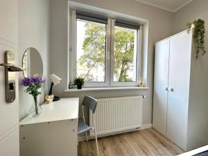 een badkamer met een wit bureau en een raam bij MMRent Jellyfish Room in Gdańsk