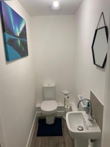een badkamer met een wit toilet en een wastafel bij Very large double room with corner sofa and Sky TV in Newhaven