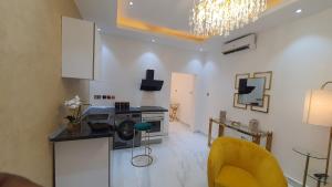 a living room with a microwave and a yellow chair at The Vittins in Accra