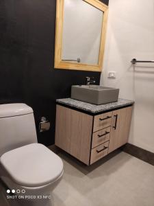 La salle de bains est pourvue de toilettes blanches et d'un lavabo. dans l'établissement Bello Monoambiente en El Prado, à Cochabamba