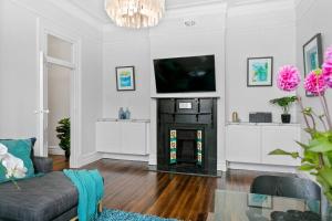 een woonkamer met een open haard en een televisie bij EDW19 - Stylish 2-Bed, 2-Bath Townhose in Drummoyne in Sydney