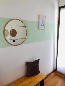 a mirror on a wall next to a wooden table at Alloggio ai piedi del Cansiglio 