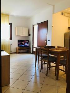 a kitchen and dining room with a table and a television at Alloggio ai piedi del Cansiglio 