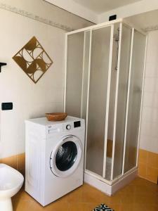 uma máquina de lavar roupa na casa de banho com uma máquina de lavar roupa em Alloggio ai piedi del Cansiglio 