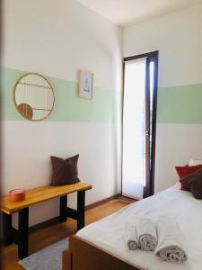 a bedroom with a bed and a table and a mirror at Alloggio ai piedi del Cansiglio 