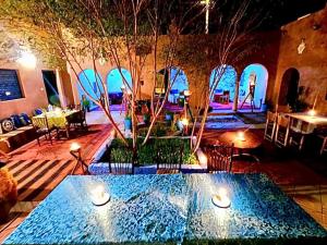 una stanza con una piscina d'acqua con luci di Riad Assia Foum Zguid a Foum Zguid