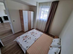 Kleines Zimmer mit einem Bett und einem Fenster in der Unterkunft Apartament CWA 3 Aeroport Otopeni in Otopeni