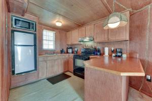 cocina con armarios de madera y encimera en Waterfront Jonesville Studio on Black River Lake!, 