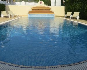 a swimming pool with a pool table and chairs at Villa Moments - Guest House in Portimão