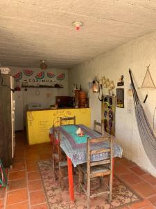 a kitchen with a table and chairs in a room at Hostel Flor da Vida in Canoa Quebrada