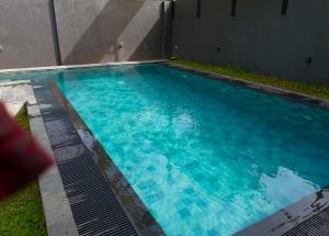 a large swimming pool with blue water at Negombo Morawala Beach Villa in Negombo