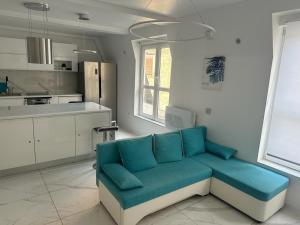 a living room with a blue couch in a kitchen at Seven Luxury Suites in Belgrade
