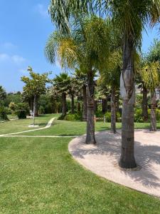 einen Weg durch einen Park mit Palmen in der Unterkunft Refúgio do Lago in Frossos