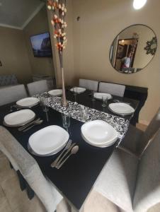 mesa de comedor con placas blancas y espejo en Casa la bendecida II en Santiago del Estero