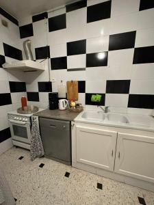 a kitchen with a black and white checkered wall at Luxeux et Idéal à Marsa Plage vue sur Mer in La Marsa