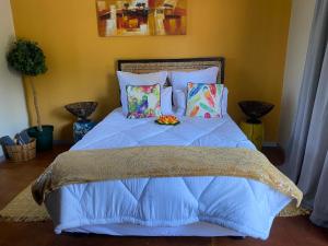 a bed with a blue comforter with a plate of fruit on it at RRT Retreat Oasis in Pretoria