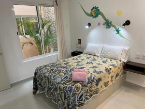 a bedroom with a bed with a pink pillow on it at Porto Regina Suite in Cancún