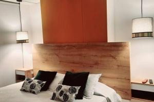 um quarto com uma cabeceira em madeira e uma cama com almofadas em Lujoso Apartaestudio em Ibagué