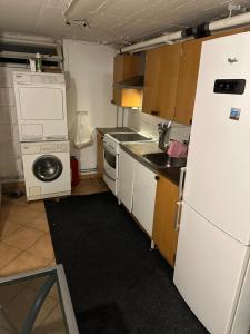a small kitchen with a white refrigerator and a dishwasher at Room A in Malmö