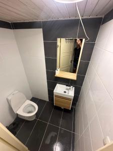 a person taking a picture of a bathroom with a toilet and sink at Room A in Malmö