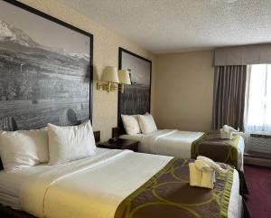 a hotel room with two beds and a window at Super 8 by Wyndham Lethbridge in Lethbridge