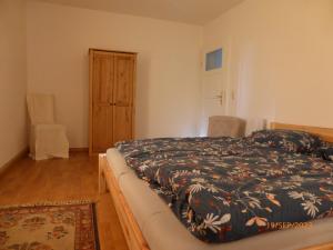 a bedroom with a bed with a black and white blanket at Natur pur im Erzgebirge in Breitenbrunn
