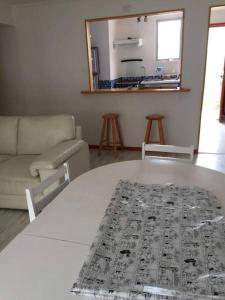 a living room with a white table and a couch at Casa de dos pisos a pasos de la playa in Caldera
