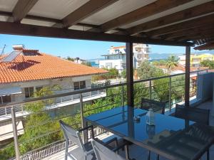 d'un balcon avec une table bleue et des chaises blanches. dans l'établissement Peraia Sea view Apartment, à Néoi Epivátai