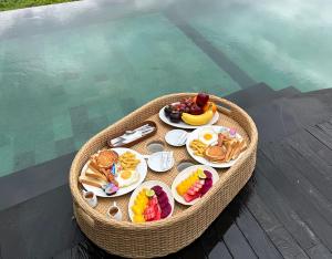 una bandeja de alimentos para el desayuno en una mesa en una cesta en Nana Suites Villa en Sidemen