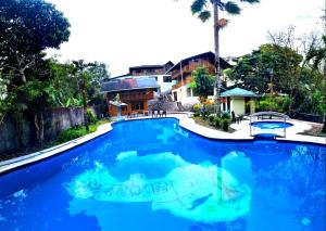 een zwembad met blauw water in een resort bij HOTEL LAS TANGARAS DE MINDO in Mindo