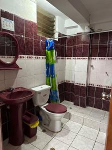 y baño con aseo y lavamanos. en Hospedaje Qorichaska's en Cusco