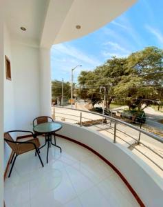 una mesa y una silla en un balcón con vistas en D'eluxe Hotel Talara, en Talara
