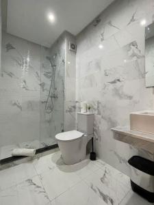 a white bathroom with a toilet and a shower at Chic & cosy appartement au centre d’Oujda in Oujda