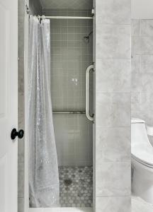 y baño con ducha y cortina de ducha. en Santorini, en Omaha