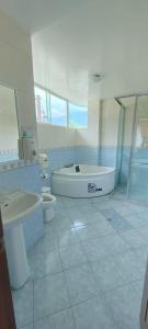 a bathroom with a tub and a sink and a toilet at HOTEL LAS TANGARAS DE MINDO in Mindo